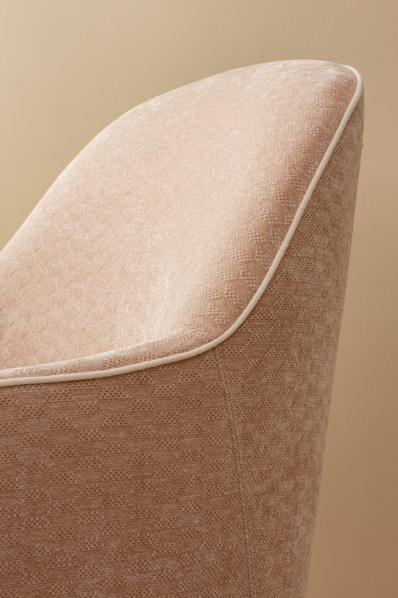 a close up of a chair with a tan background