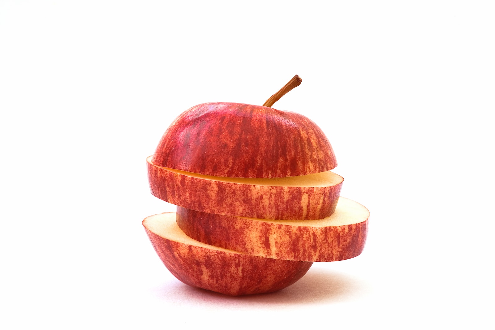an apple sliced in half with a bite taken out of it